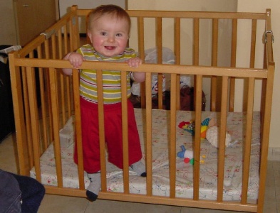 Robert learns to stand in his holiday cot